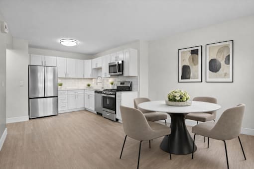 A modern kitchen with a dining table set for four.