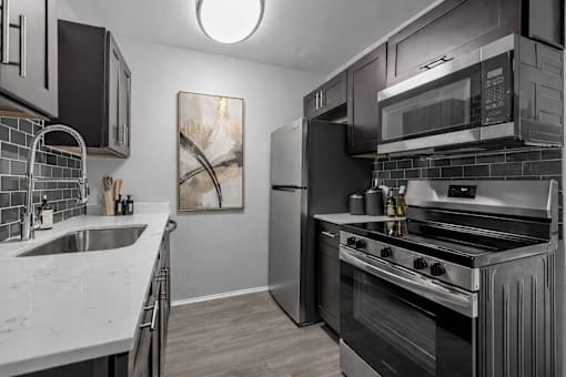 A modern kitchen with a stainless steel oven and microwave.