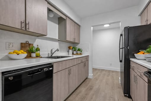 A kitchen with black appliances and wooden cabinets.