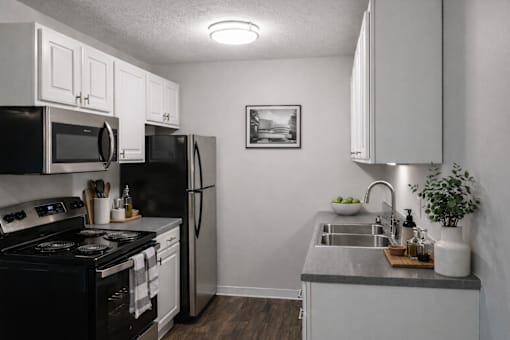 A kitchen with black appliances and white cabinets.