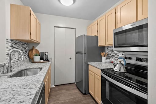 A kitchen with a sink, refrigerator, and stove.