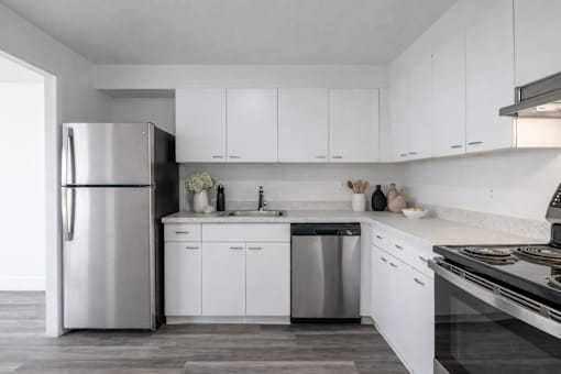 A modern kitchen with white cabinets and stainless steel appliances.