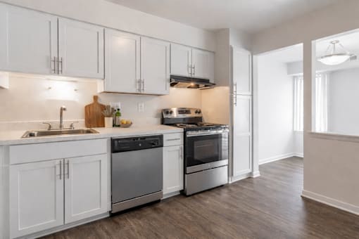 A modern kitchen with white cabinets and stainless steel appliances.