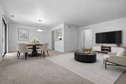 A modern living room with a dining table and chairs.