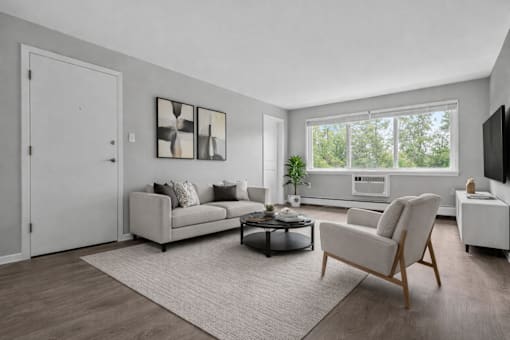 A living room with a grey couch, a white armchair, and a coffee table.