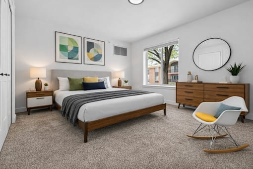 A bedroom with a bed, nightstands, and a chair.