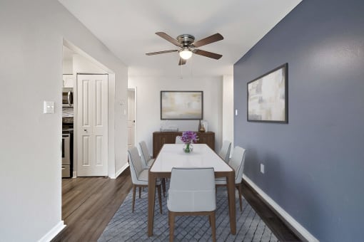 a dining room with a table and chairs and a ceiling fan