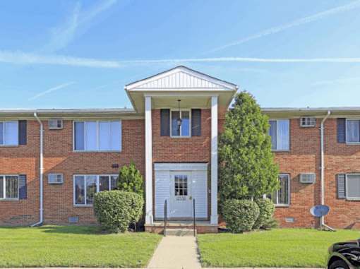 A red brick building with a white door and windows.