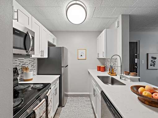 A kitchen with white cabinets and a black stove top.