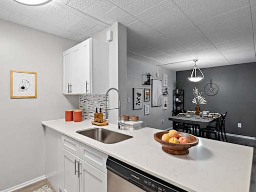 A kitchen with a marble countertop and a bowl of fruit on it.