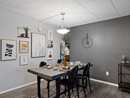 A dining room with a table set for a meal.