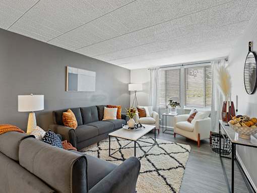 A living room with a grey couch, a white armchair, and a coffee table.