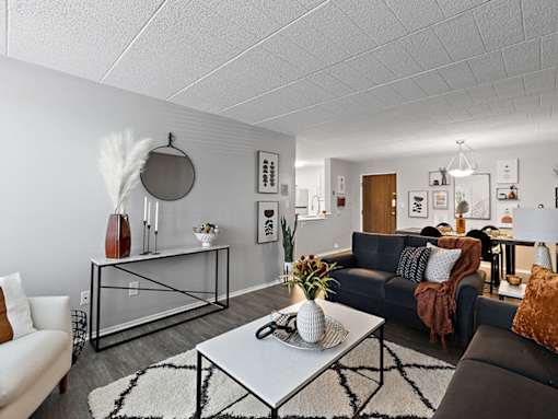 A living room with a black couch and a white coffee table.
