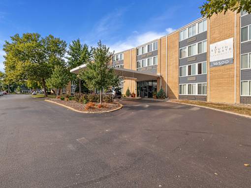 A parking lot in front of a brick building with a sign that reads "Southpointe".