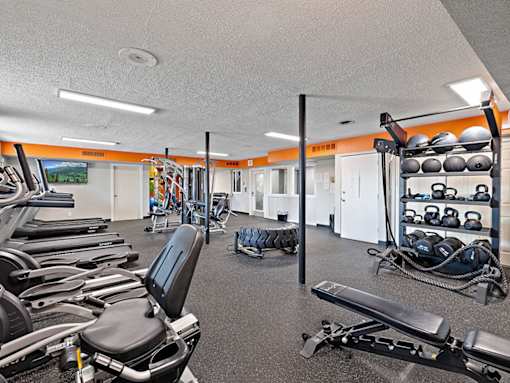 A gym with a variety of equipment including weights and machines.