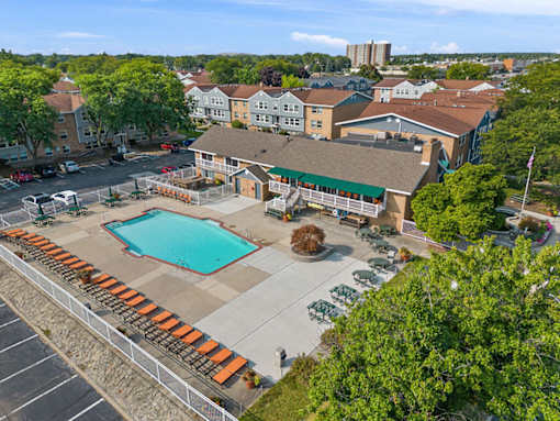 A pool surrounded by bleachers in a residential area.