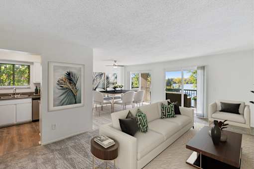 A living room with a white couch and a painting on the wall at The Waverly on the Lake - Belleville, MI Apartment , Belleville