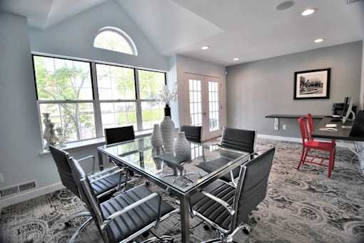 A modern dining room with a glass table and chairs.