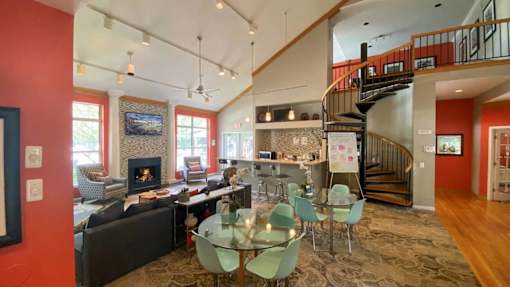 A living room with a fireplace and a spiral staircase.