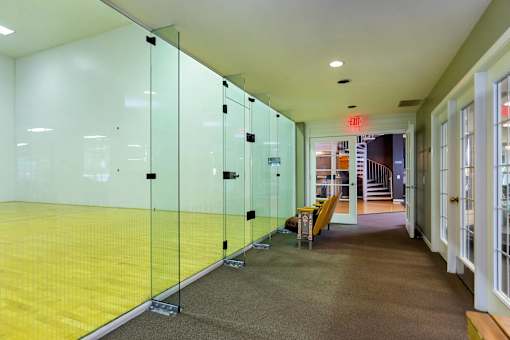 A hallway with glass walls and a yellow floor.