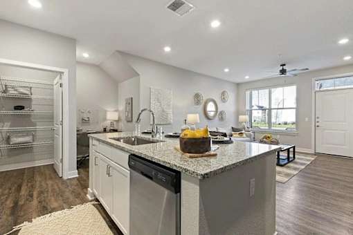 A modern kitchen with a granite countertop and stainless steel appliances.