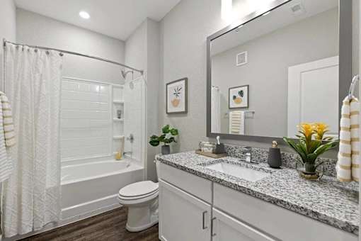 A bathroom with a white toilet, a white sink, and a white bathtub.