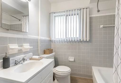 A white bathroom with a toilet, sink, and tub.