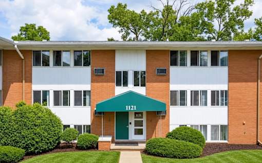 A building with a green awning and the number 1121 on it.