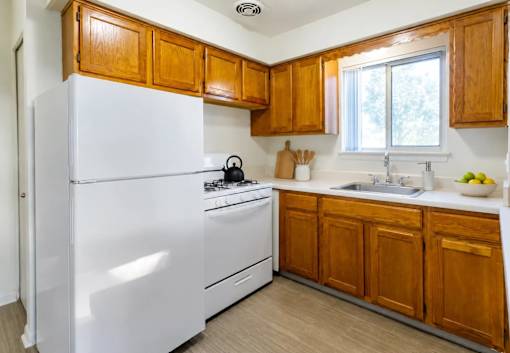 A kitchen with wooden cabinets and white appliances.