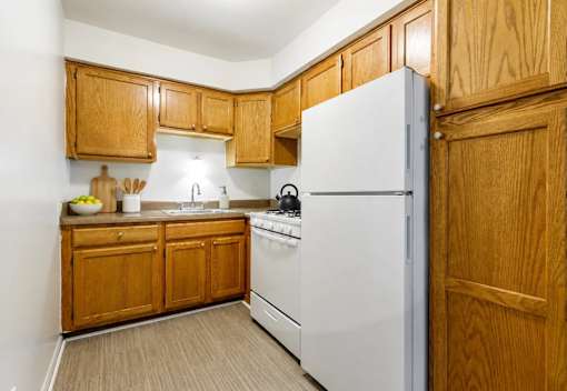 A kitchen with wooden cabinets and a white refrigerator.
