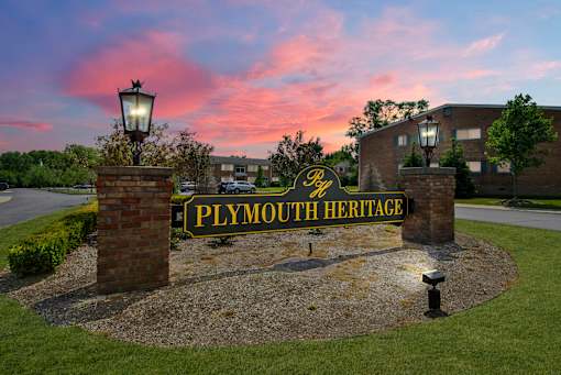 A sign that says "Plymouth Heritage" is in front of a building.