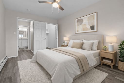 A bedroom with a large bed and a ceiling fan.
