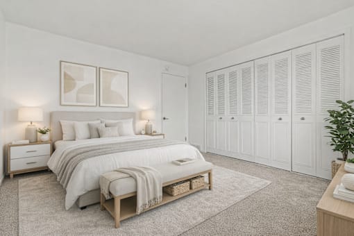 A bedroom with a large bed, a nightstand, and a wardrobe.