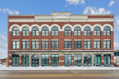 A red brick building with a white sign on the top.