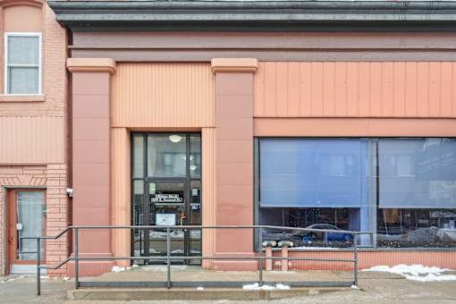 A building with a pink facade and a black awning.