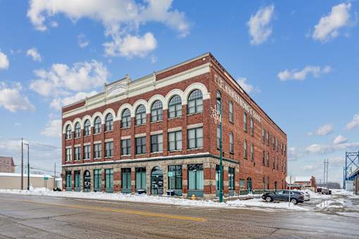A red brick building with arched windows and a sign that says "The Brownstone".