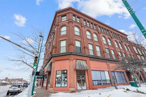 A red brick building with a green awning and a green traffic light.