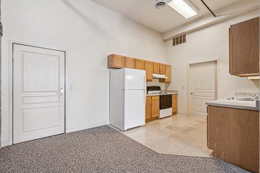 A kitchen with white appliances and wooden cabinets.