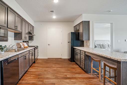 A kitchen with wooden floors and a white counter top.