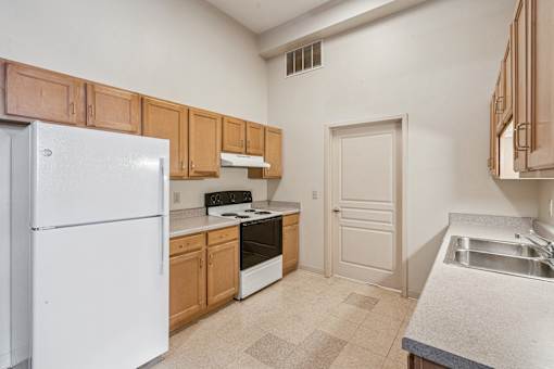 A kitchen with white appliances and wooden cabinets.