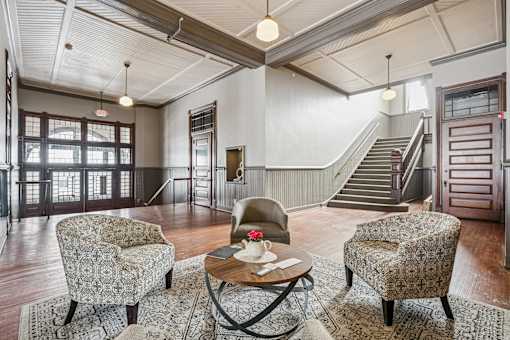 A living room with a staircase in the background.