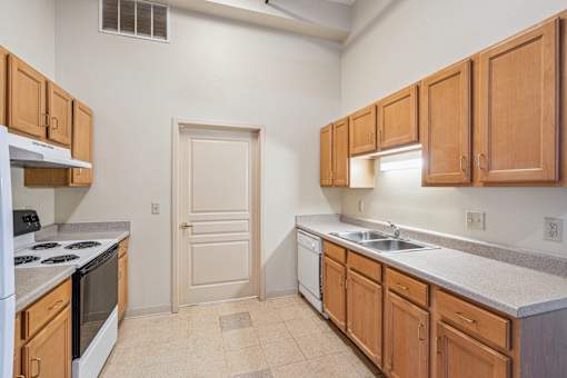 A kitchen with wooden cabinets and a white stove top oven.