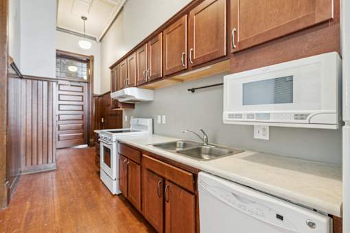A kitchen with white appliances and wooden cabinets.