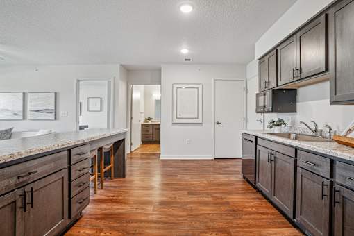 A kitchen with dark wood cabinets and a white counter top.