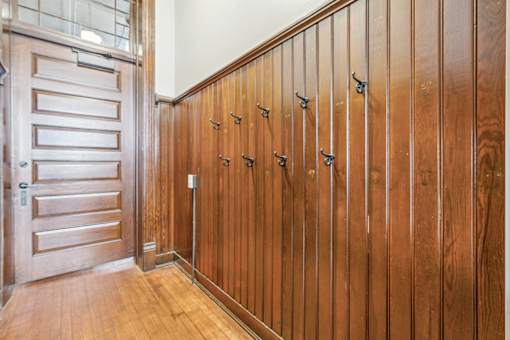 A wooden door with a handle and a wooden wall with a mirror.