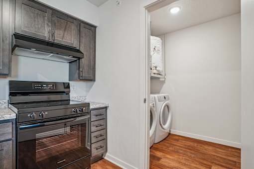 A kitchen with a stove top oven and a washing machine.