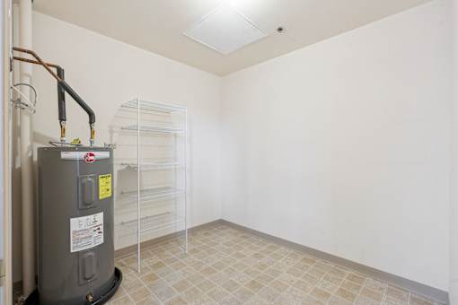 A room with a water heater and a tiled floor.