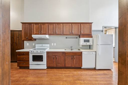 A kitchen with white appliances and wooden cabinets.