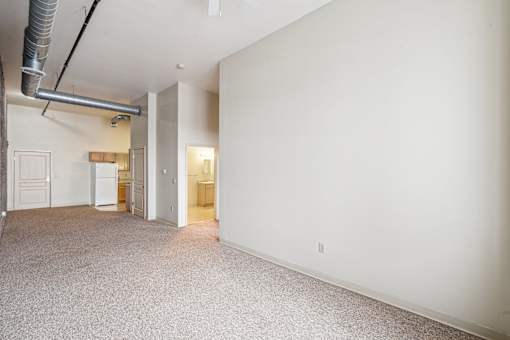 A large empty room with a carpeted floor and white walls.