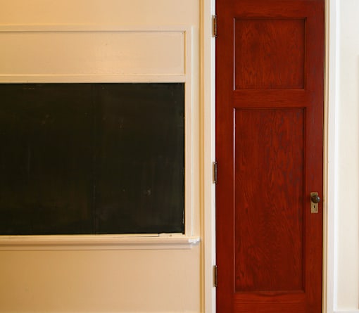 A brown door is next to a window.